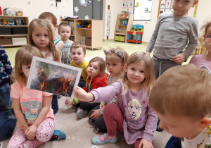 Dziewczynka pokazuje obrazek z pożarem